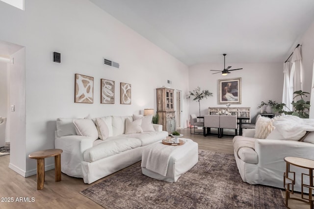 living room with ceiling fan, high vaulted ceiling, and hardwood / wood-style floors