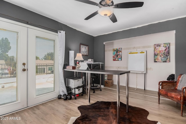 home office with french doors, ceiling fan, and light wood-type flooring