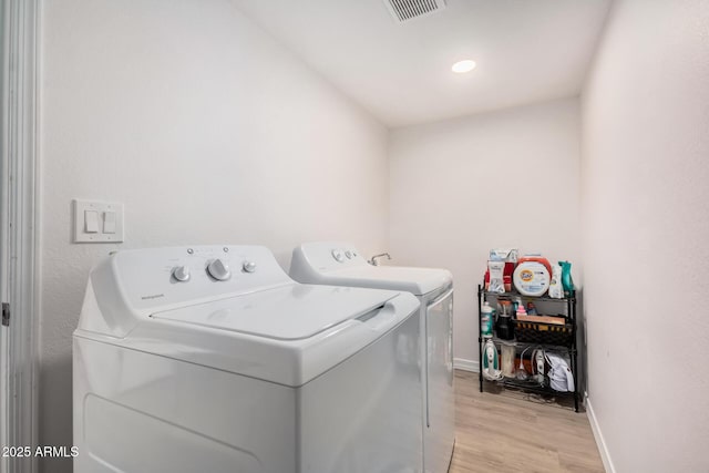 laundry room featuring separate washer and dryer and light wood-type flooring