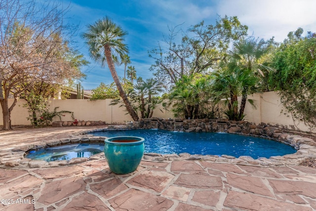 view of pool featuring a patio area and an in ground hot tub