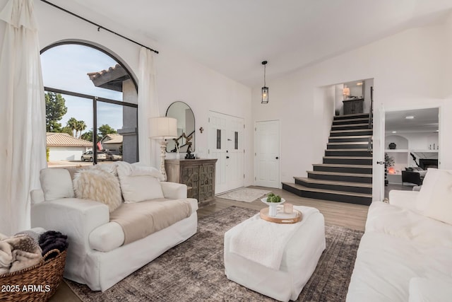 living room with hardwood / wood-style floors and high vaulted ceiling