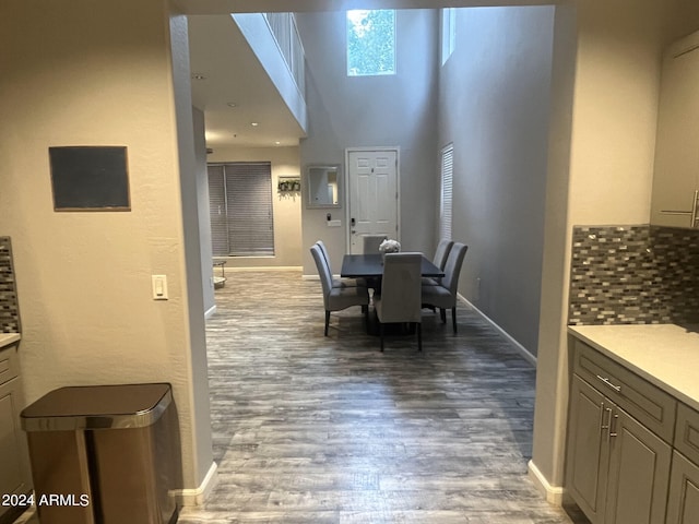 dining area featuring a towering ceiling and hardwood / wood-style flooring