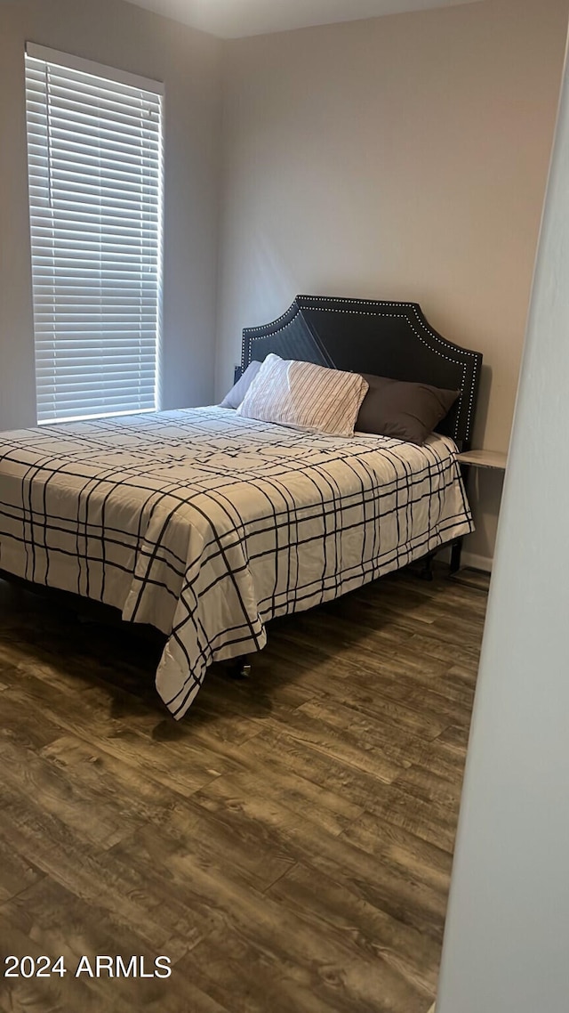 bedroom with dark wood-type flooring