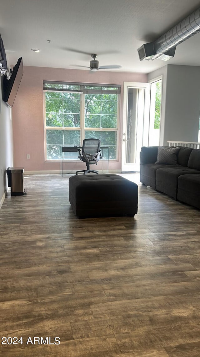 living room with dark hardwood / wood-style flooring and ceiling fan