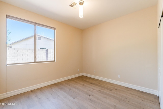 unfurnished room with light wood-type flooring, visible vents, and baseboards