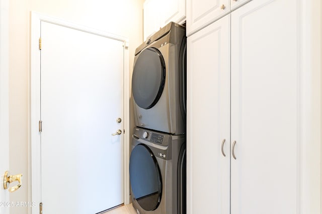 washroom with cabinet space and stacked washing maching and dryer