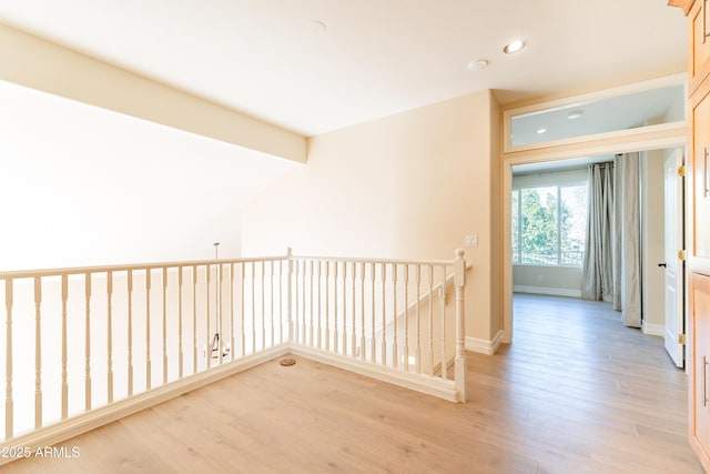 hallway featuring light wood-type flooring, baseboards, an upstairs landing, and recessed lighting