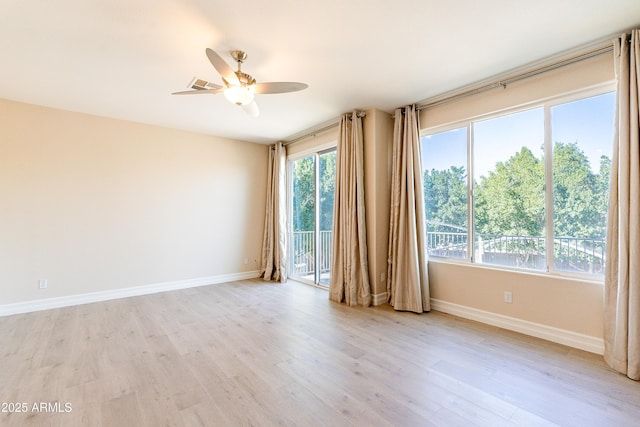 spare room with baseboards, ceiling fan, and light wood-style floors