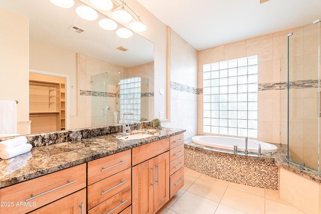 bathroom featuring a walk in closet, visible vents, a stall shower, vanity, and tile patterned flooring