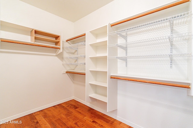 walk in closet with wood finished floors