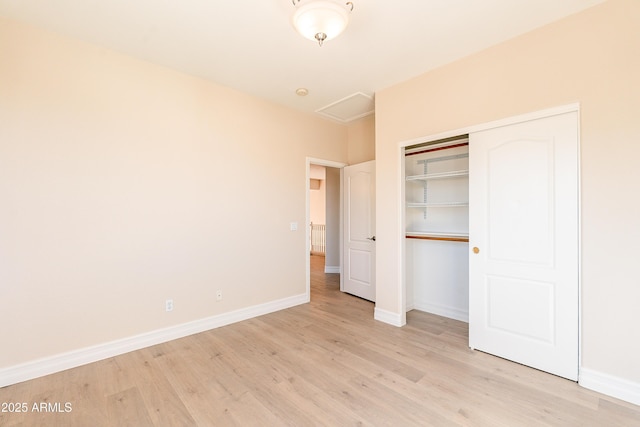 unfurnished bedroom with light wood finished floors, a closet, and baseboards