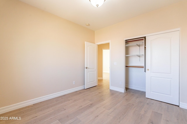 unfurnished bedroom with light wood-style floors, a closet, and baseboards