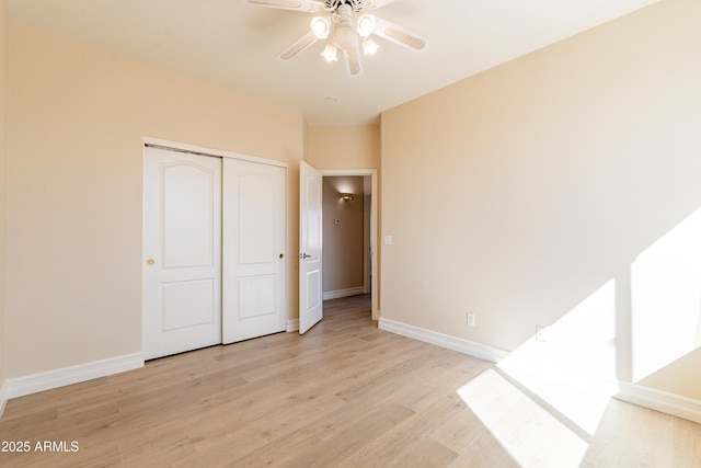 unfurnished bedroom with a ceiling fan, light wood-type flooring, a closet, and baseboards