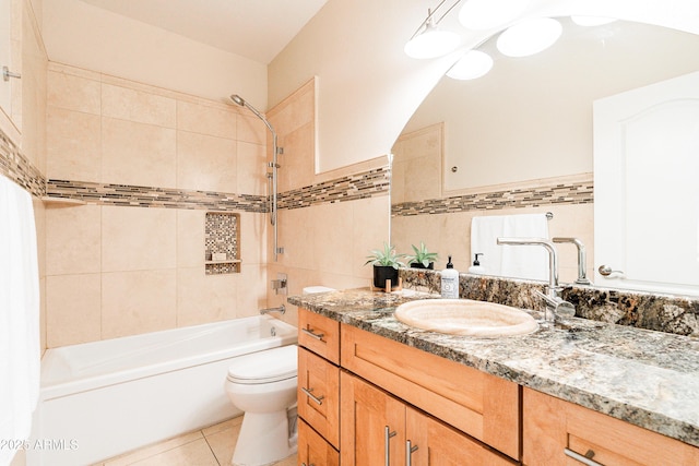 bathroom with shower / bath combination, toilet, tile patterned flooring, vanity, and tile walls