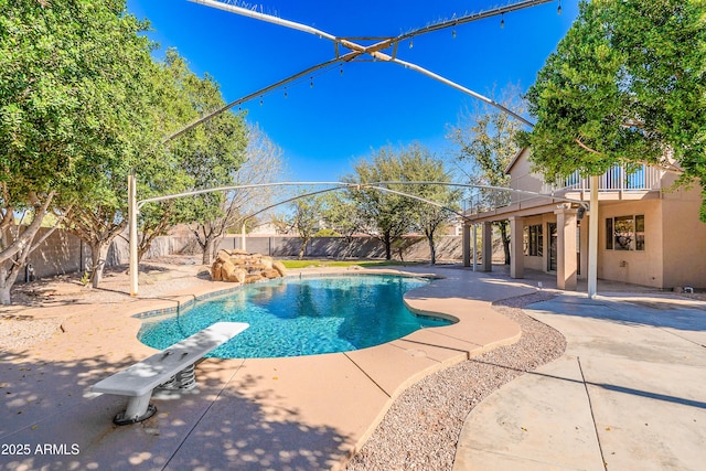 view of pool with a diving board, a patio, a fenced backyard, and a fenced in pool