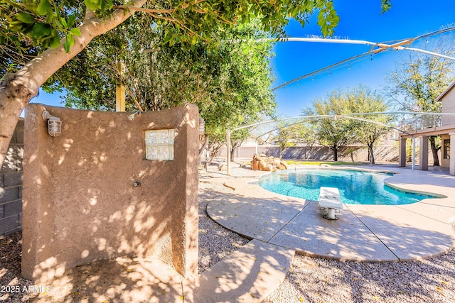 view of swimming pool with a fenced backyard, a diving board, a fenced in pool, and a patio