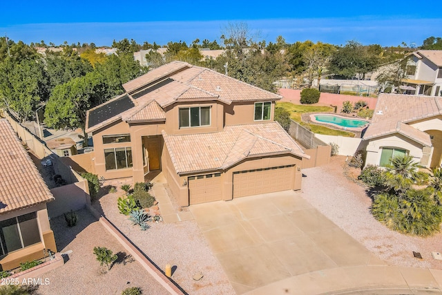 mediterranean / spanish-style house with stucco siding, concrete driveway, a garage, a fenced backyard, and a tiled roof