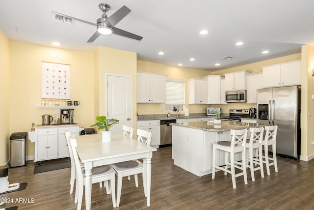 kitchen with white cabinetry, a center island, dark hardwood / wood-style floors, and appliances with stainless steel finishes