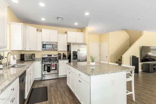 kitchen featuring white cabinetry, a center island, dark hardwood / wood-style floors, and appliances with stainless steel finishes