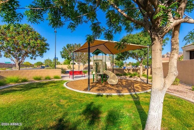 view of home's community with a playground and a yard