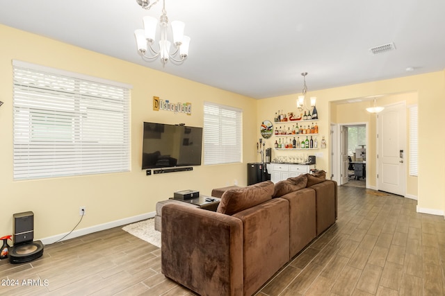 living room featuring light wood-type flooring and a notable chandelier