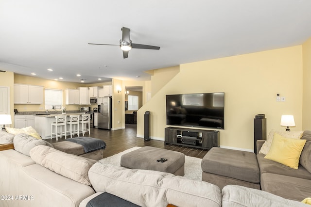 living room with dark hardwood / wood-style flooring and ceiling fan