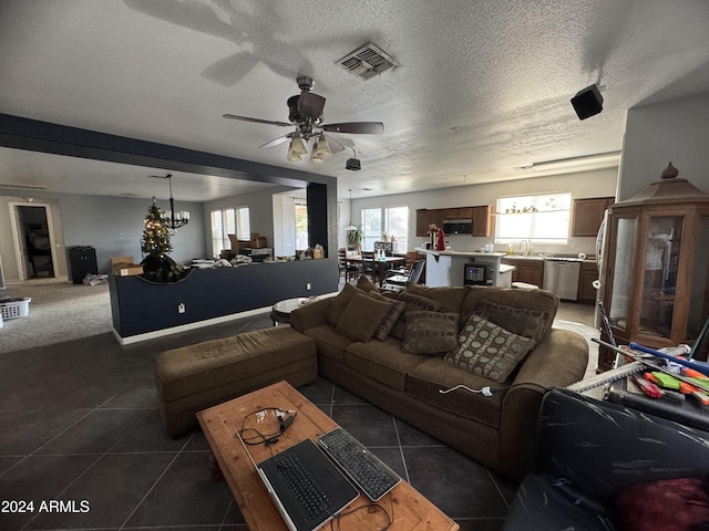 tiled living room with a textured ceiling, ceiling fan with notable chandelier, and sink