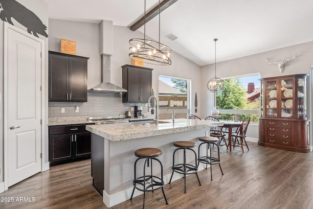 kitchen with a kitchen breakfast bar, a sink, an inviting chandelier, dark wood-type flooring, and vaulted ceiling with beams