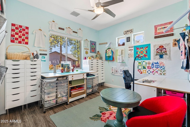 office area with dark wood-style flooring, visible vents, a ceiling fan, and baseboards