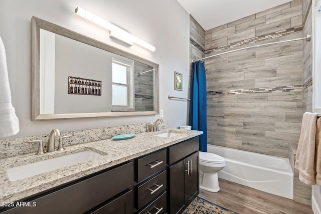 full bath featuring toilet, shower / bath combo, a sink, and wood finished floors