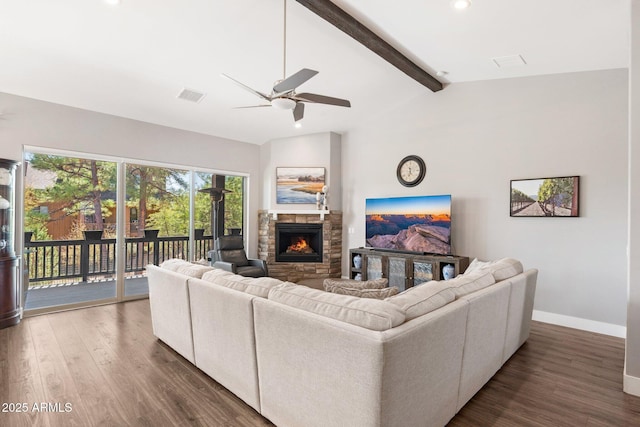 living room featuring visible vents, ceiling fan, baseboards, vaulted ceiling with beams, and a stone fireplace