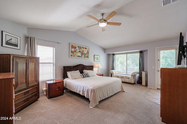 bedroom featuring ceiling fan, light carpet, and multiple windows