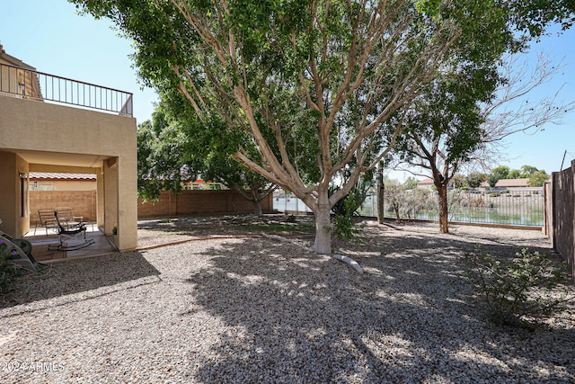 view of yard with a water view and a patio