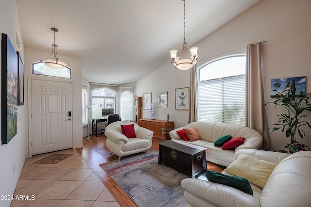 living room featuring lofted ceiling, a notable chandelier, and light hardwood / wood-style flooring