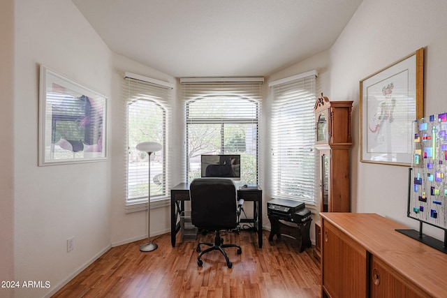 office featuring vaulted ceiling and light hardwood / wood-style floors