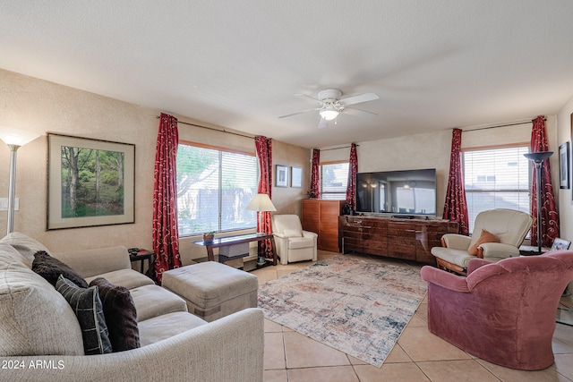 tiled living room with ceiling fan, a wealth of natural light, and a textured ceiling