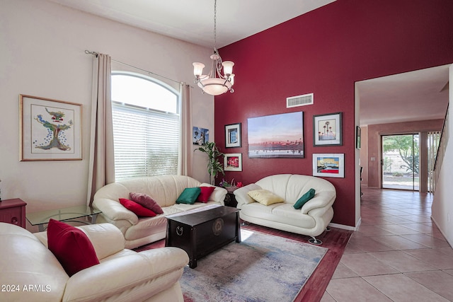 tiled living room featuring a high ceiling and an inviting chandelier