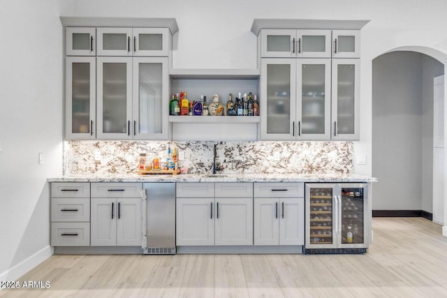 bar featuring gray cabinetry, decorative backsplash, light stone counters, and wine cooler