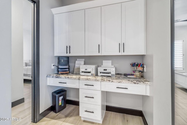 office area featuring built in desk and light hardwood / wood-style flooring