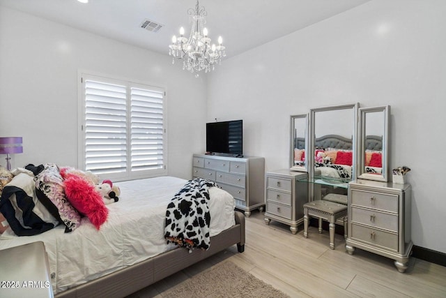 bedroom featuring light wood-type flooring and an inviting chandelier