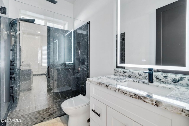 bathroom featuring vanity, toilet, and a shower with shower door