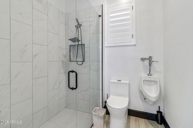 bathroom featuring toilet and a shower with shower door