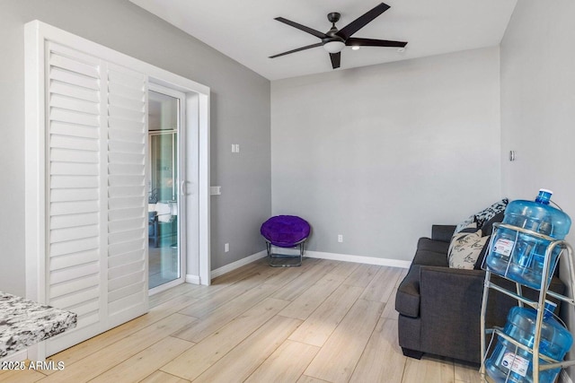 living area with hardwood / wood-style floors and ceiling fan