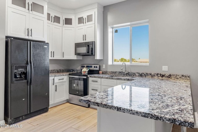 kitchen featuring kitchen peninsula, sink, white cabinets, and black appliances