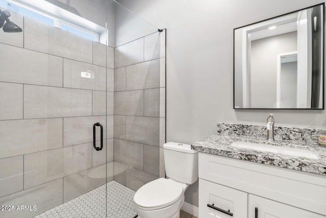 bathroom with vanity, toilet, and a shower with shower door