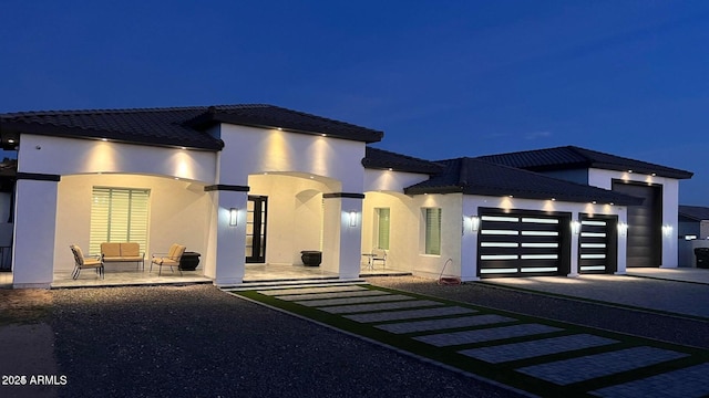 view of front of property featuring a garage and a patio area