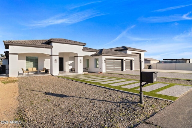 view of front of property featuring a patio and a garage