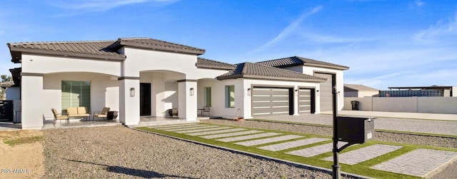 mediterranean / spanish house featuring a patio area and a garage