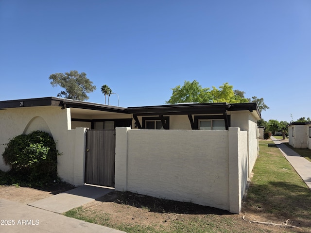 720 S Dobson Rd Unit 24, Mesa, AZ 85202 - view of front of home with fence, stucco siding, and a gate