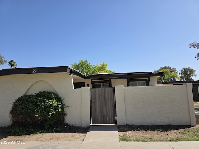 720 S Dobson Rd Unit 24, Mesa, AZ 85202 - view of front of home featuring stucco siding, fence, and a gate